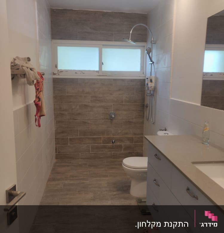 מקלחת עם ראש מקלחת עגול וקיר אריחים חום